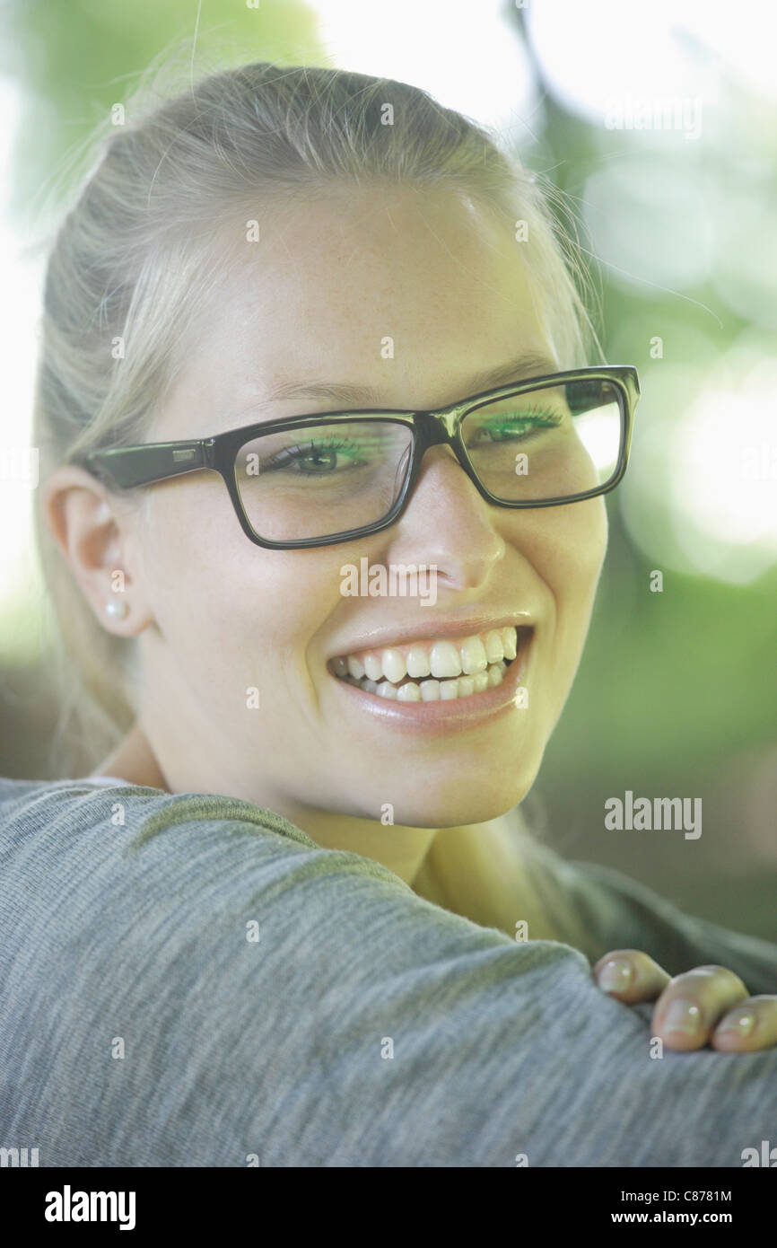 In Germania, in Baviera, Schaeftlarn, giovane donna indossando spessi occhiali bordati, sorridente, close up Foto Stock