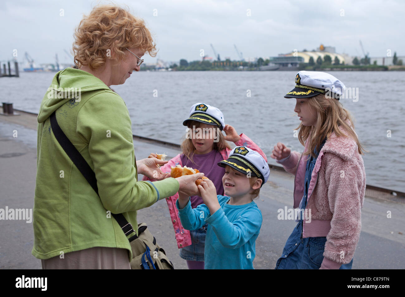 Una madre che nutre il suo giovani velisti al porto di Amburgo, Germania Foto Stock