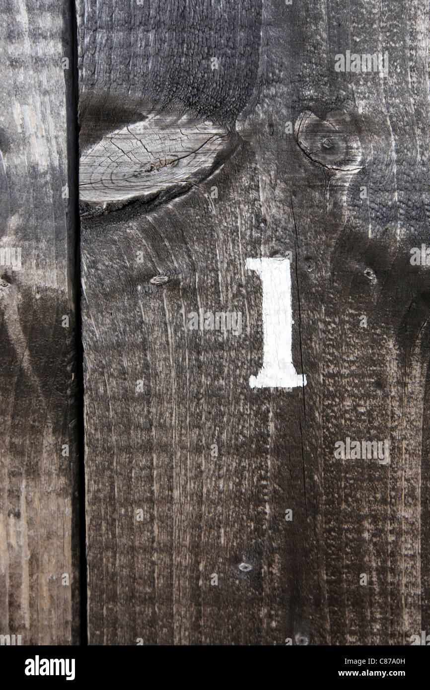 Singola cifra 1 uno onu une, stampata su colorate porta di legno, Suffolk, Regno Unito Foto Stock
