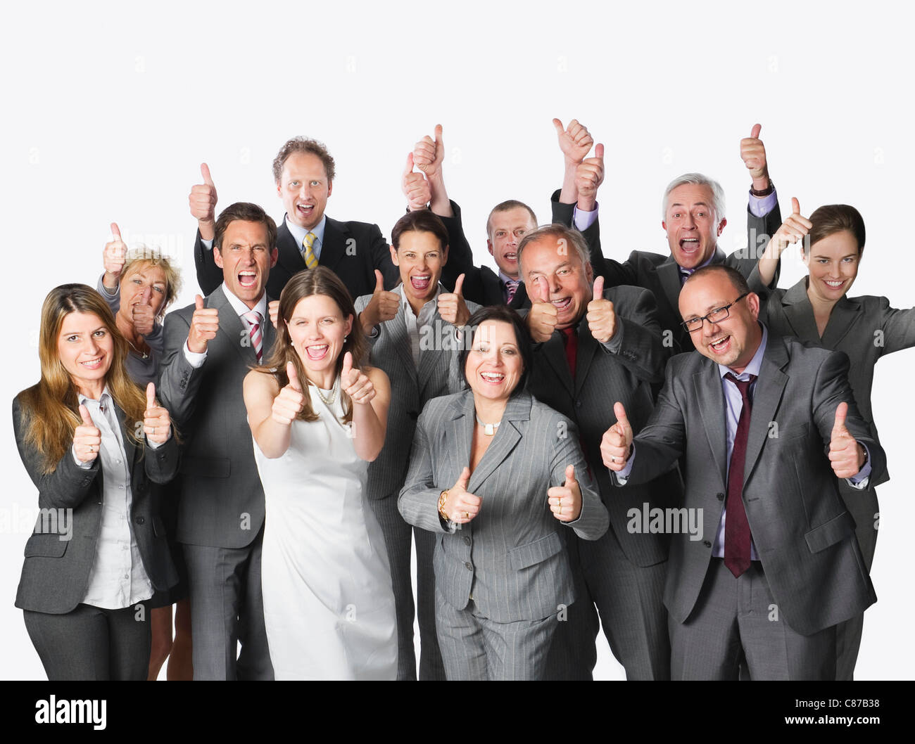 Un folto gruppo di persone di affari che mostra i pollici in su contro uno sfondo bianco Foto Stock