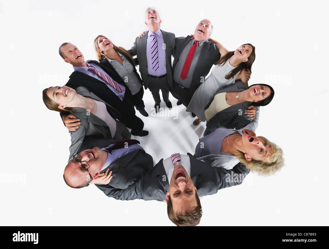 La gente di affari formando huddle e guardando verso l'alto contro lo sfondo bianco Foto Stock
