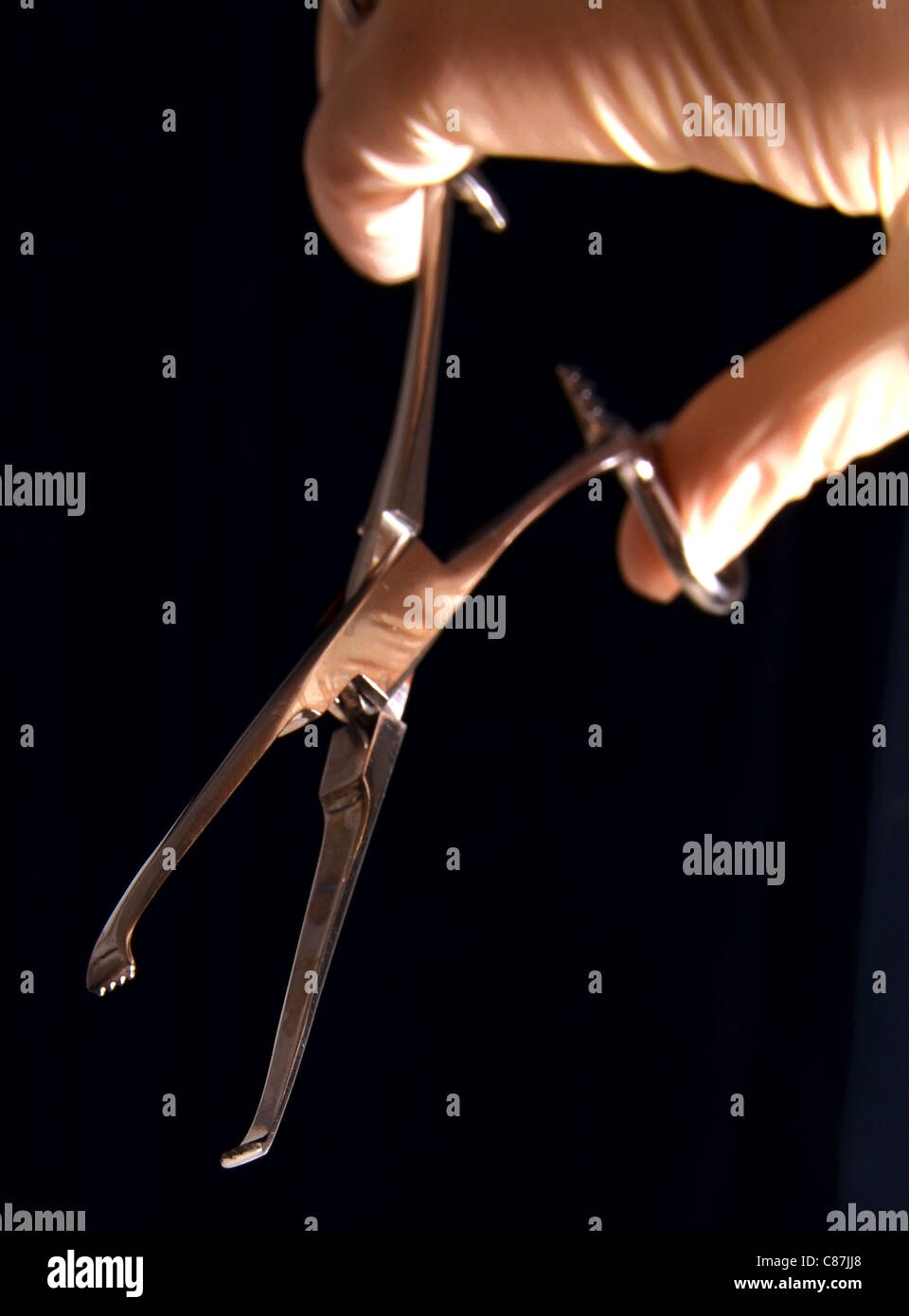 I guanti chirurgici azienda scissorlike strumento con bordo seghettato Foto Stock