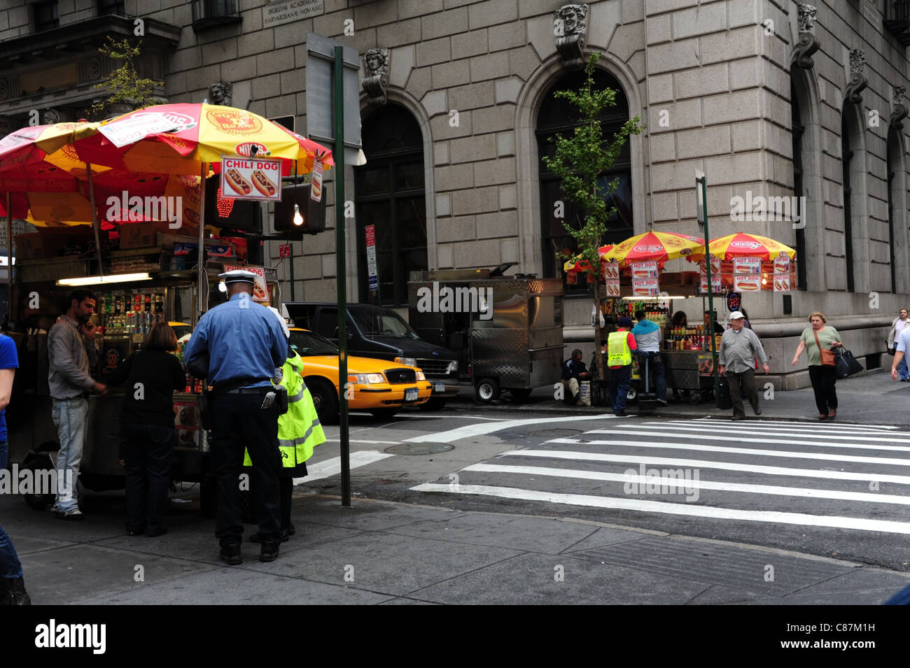 Due snack bancarelle su entrambi i lati West 54th Street , University Club sfondo, poliziotto poliziotta mangiare, la Fifth Avenue, New York Foto Stock