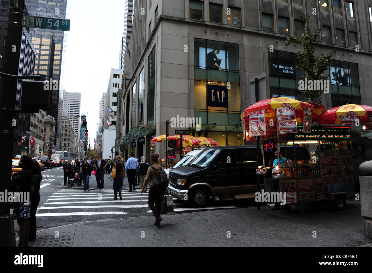 Cielo grigio autunno visualizza snack bancarelle marciapiede persone agli acquirenti di attraversamento pedonale Gap Store, West 54th Street Quinta Avenue, New York Foto Stock