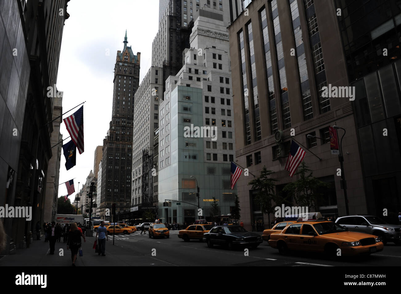 Vista verso Sherry-Netherland Hotel giallo taxi auto persone bandierine americane boutique Tiffany & Co, la Fifth Avenue, New York Foto Stock