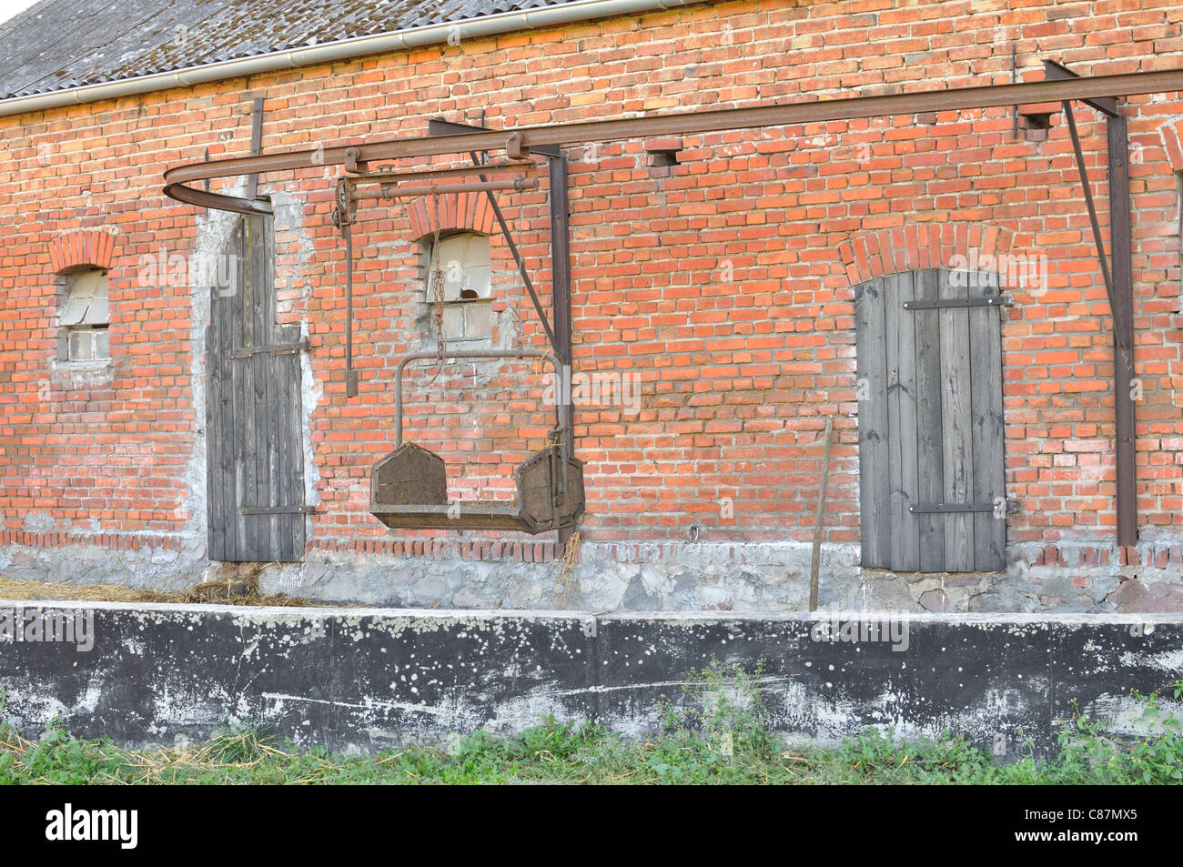 Vecchio garage fatto di mattoni rossi con sistema di trasporto di paglia in Polonia, la Masuria regione Foto Stock Vecchio garage fatto di mattoni rossi con sistema di trasporto di paglia in Polonia, la Masuria regione Foto Stock