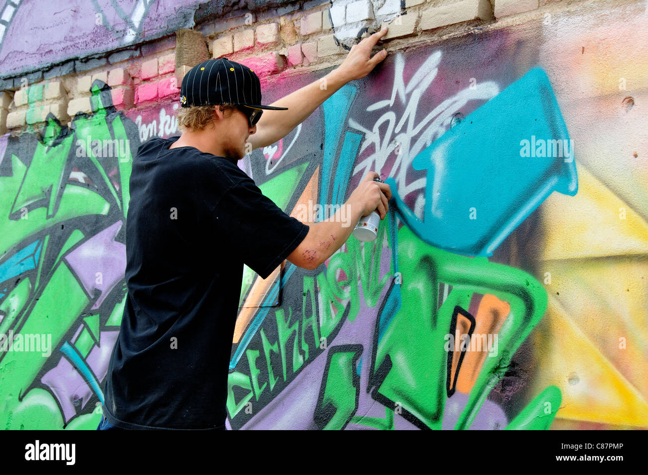Artista il design di spruzzatura su un muro di mattoni di edificio in 'Freak Alley' Foto Stock