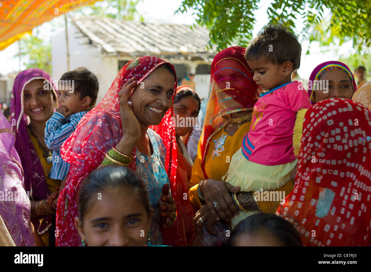 Indian nozze con gli ospiti vestiti nei loro migliori abbellito sari nel villaggio di Rohet nel Rajasthan, India settentrionale Foto Stock