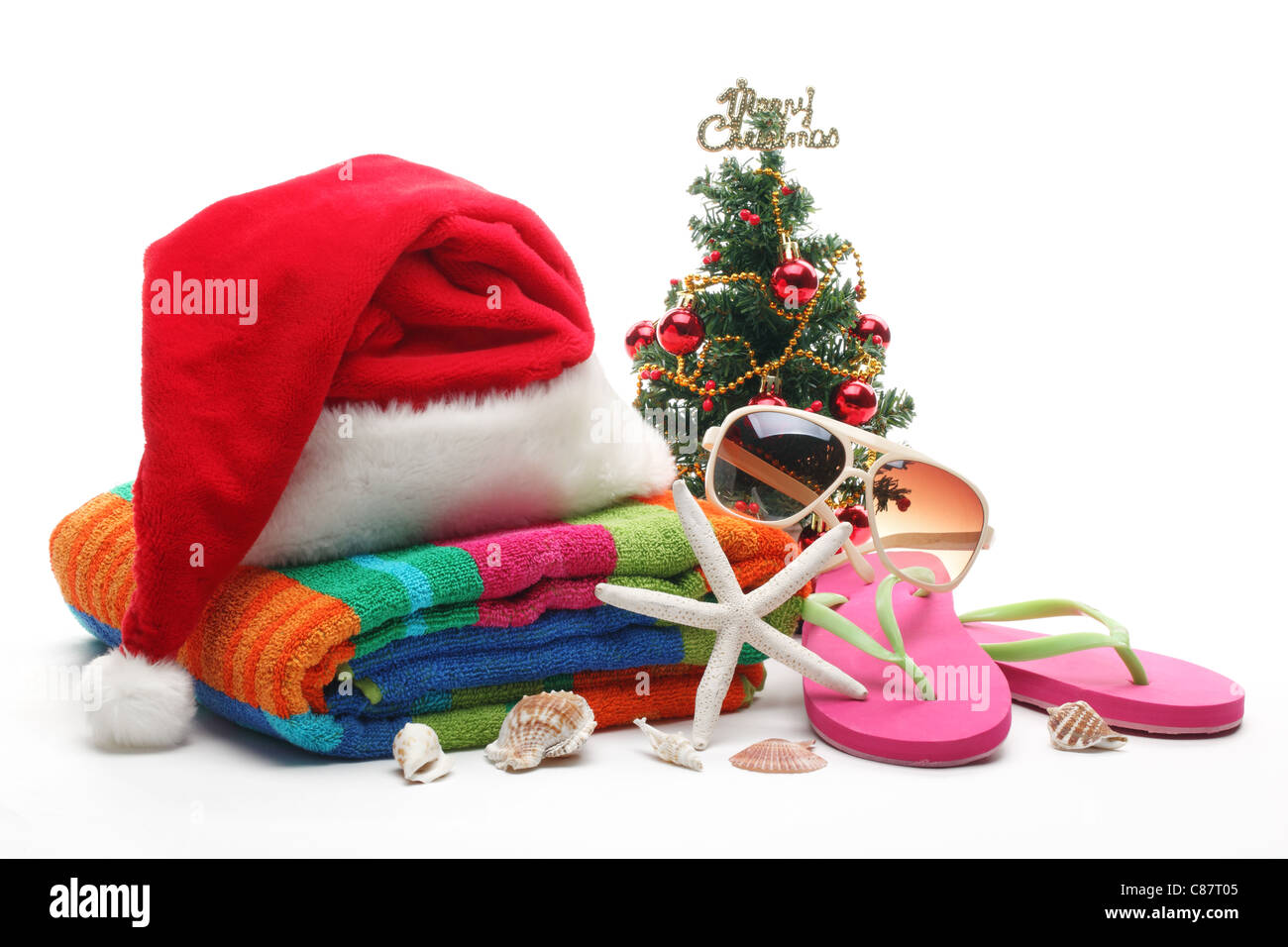 Santa Claus hat e albero di Natale con spiaggia accessori su sfondo bianco. Foto Stock