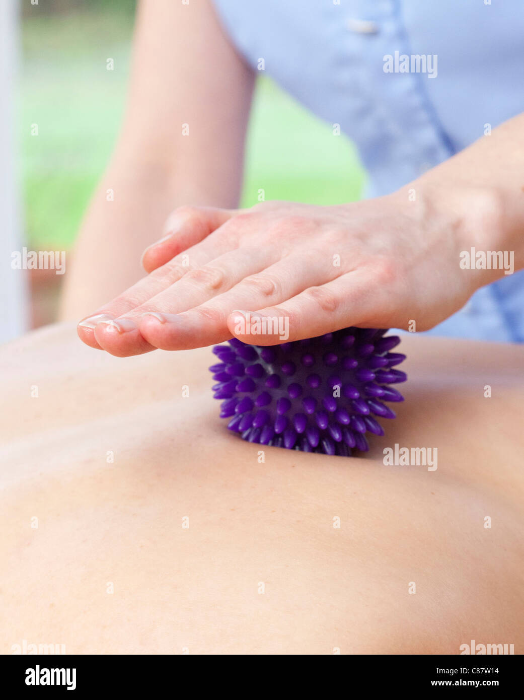 Giovane donna con la terapia di massaggio con sfera di impulso breve Foto Stock