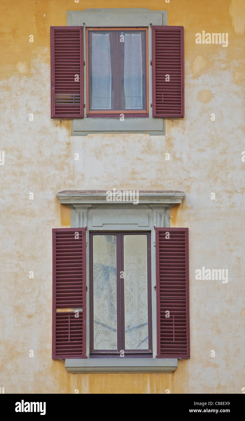 Due Weathered finestre con persiane rosse della Toscana Foto Stock