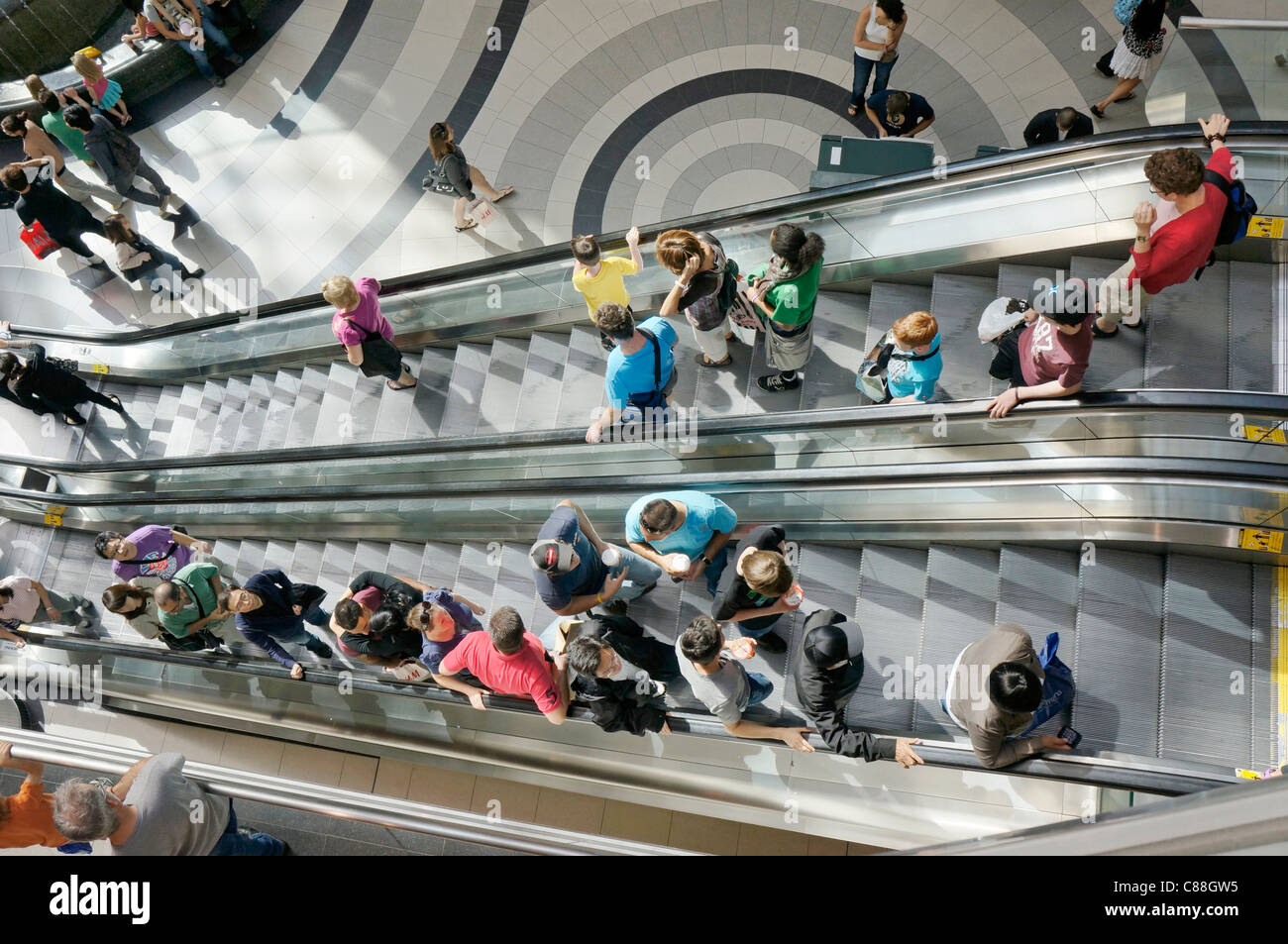 Persone su scale mobili nel centro commerciale per lo shopping Foto Stock