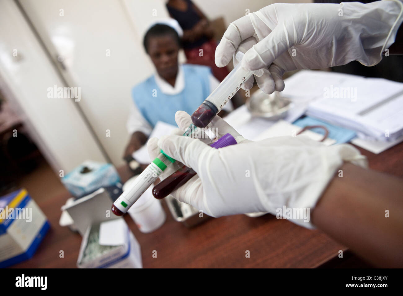 Un infermiere aspira il sangue da un HIV positiva paziente presso una clinica supportata da Catholic Relief Services a Kitwe, Zambia. Foto Stock
