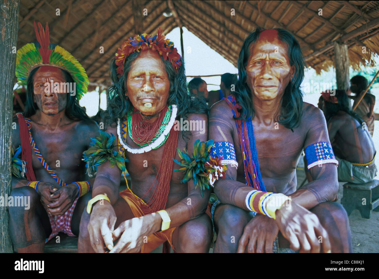 Villaggio Bacaja, Amazon, Brasile. Anziani in seduta uomini della capanna completamente adornate; Xicrin tribù. Foto Stock