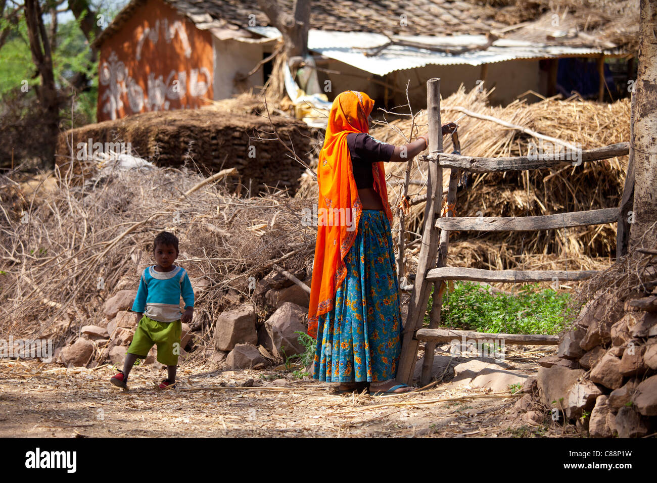 Donna indiana abitante e il bambino al suo smallholding farm at Kutalpura villaggio in Rajasthan, India settentrionale Foto Stock