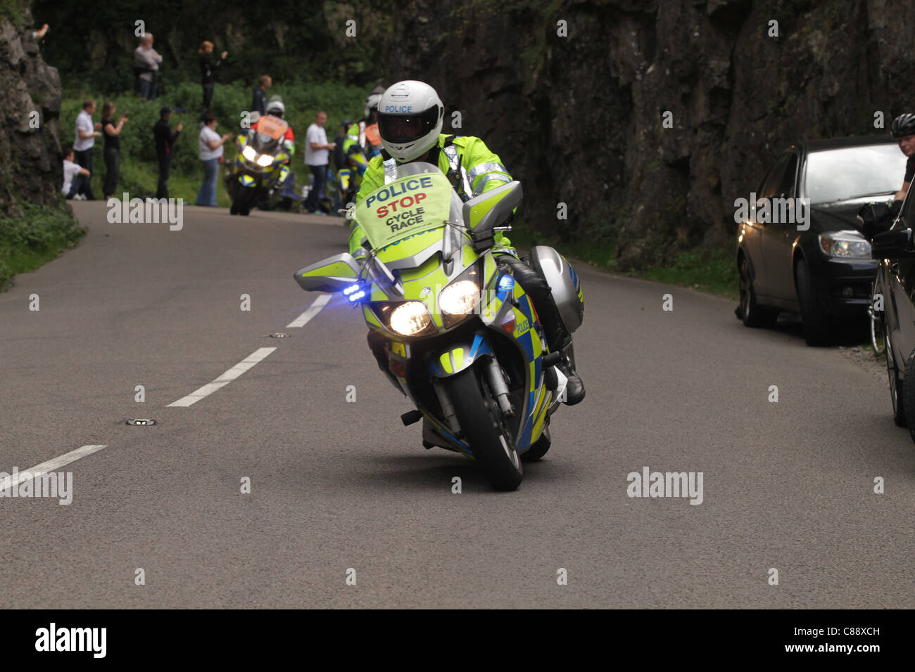 Moto della polizia in esecuzione sotto le luci blu scortando un bike race Foto Stock