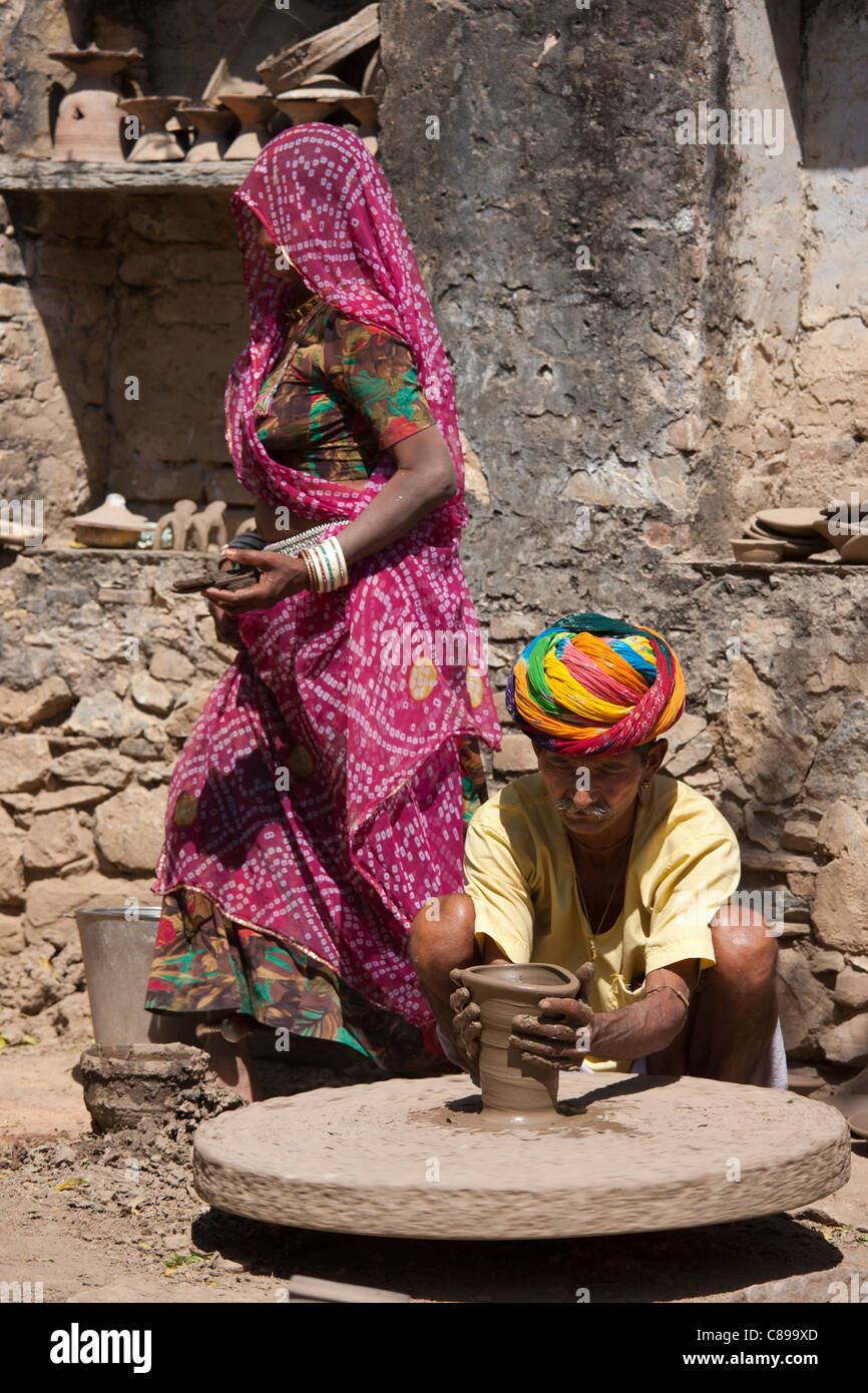 Indian potter in turbante di Rajasthani funziona con la famiglia a casa rendendo pentole di creta nel villaggio di Nimaj, Rajasthan, India Foto Stock