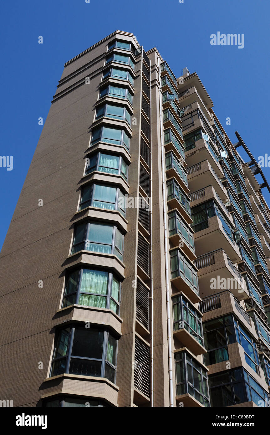 Vista dal basso di un edificio di appartamenti contro il cielo blu Foto Stock