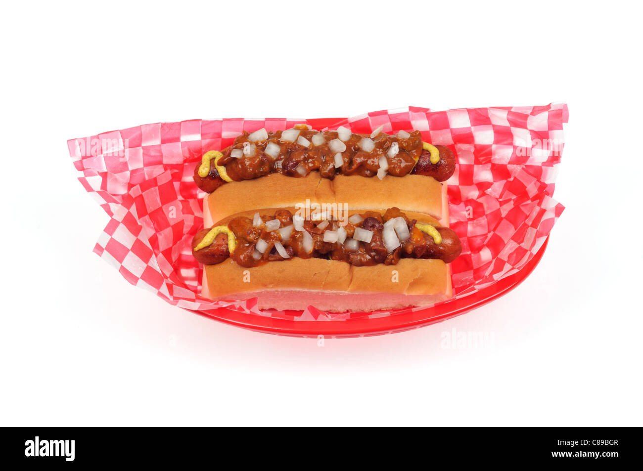 2 chili di cani con cipolle in rotoli di pane è servita nel retro rosso cesto in plastica sfondo bianco tagliato fuori Foto Stock