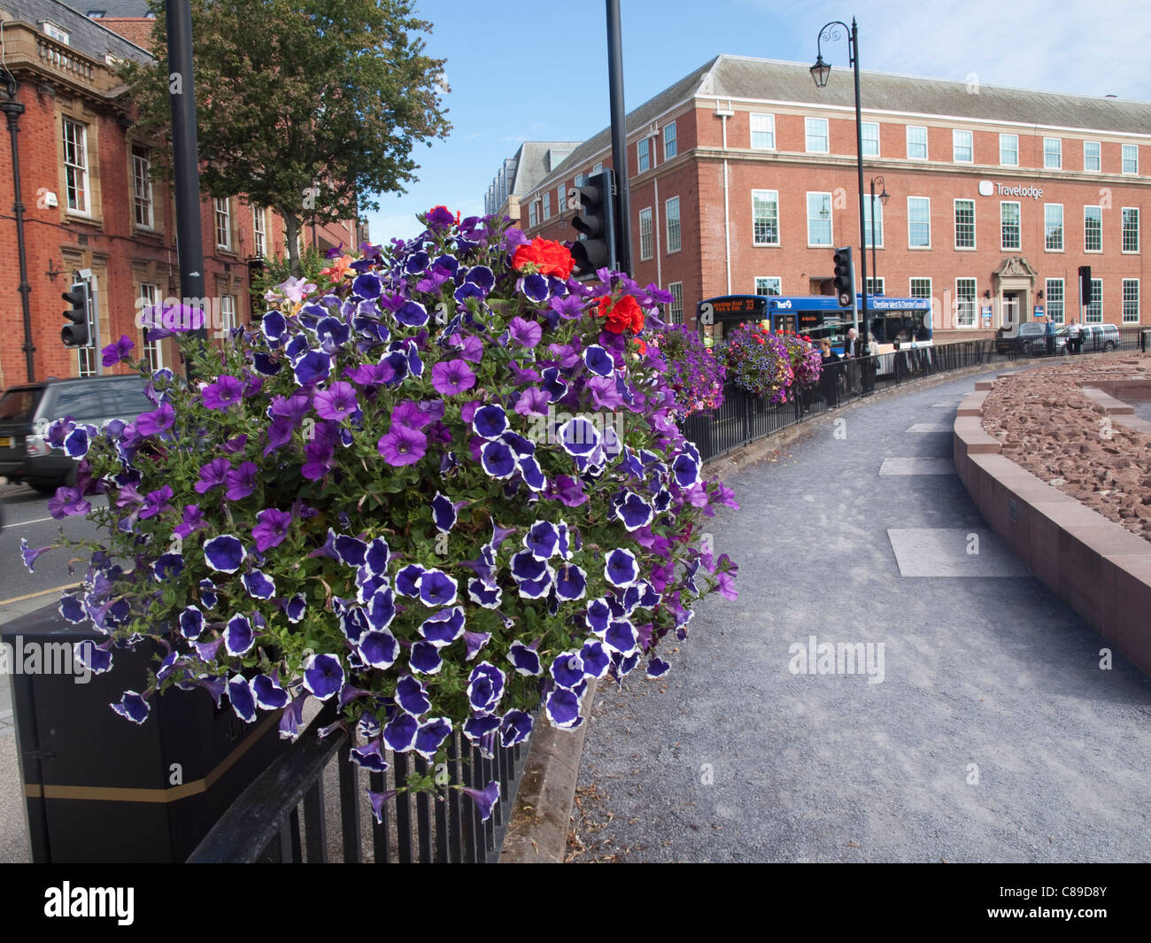 Marciapiede barriera montata street flower visualizzare caselle di Chester adiacente all'anfiteatro romano rimane e il Travelodge. Foto Stock