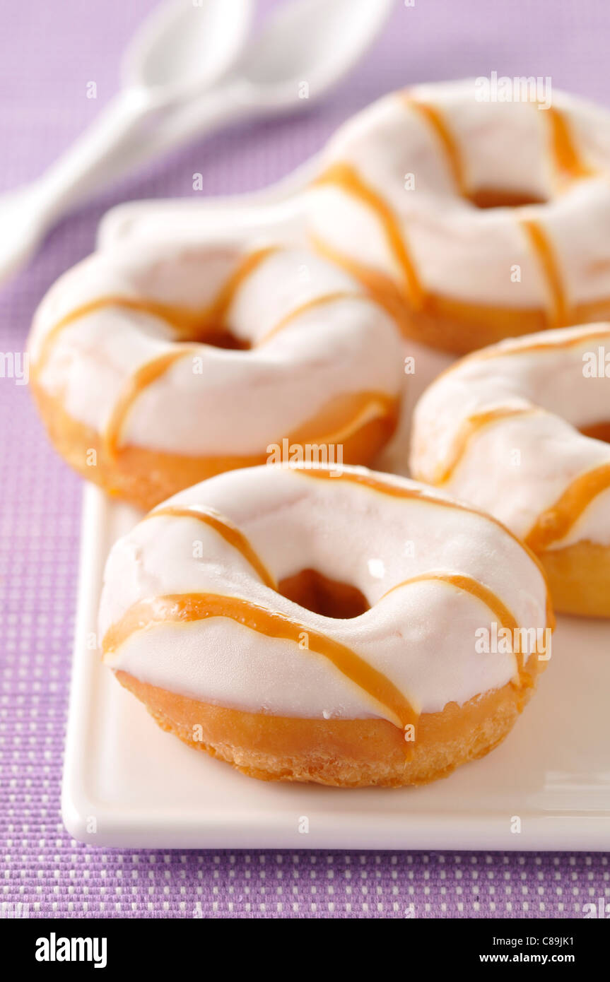 Le ciambelle ricoperte con glassa di zucchero e caramello Foto Stock