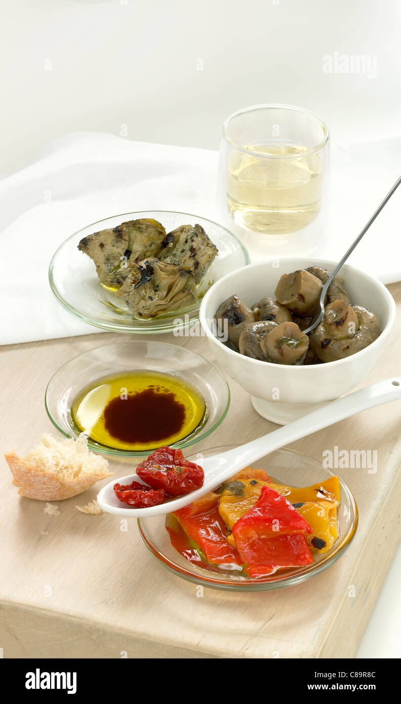 Antipasti seduto su una scheda di pane con olio d'oliva, vino e pane Foto Stock