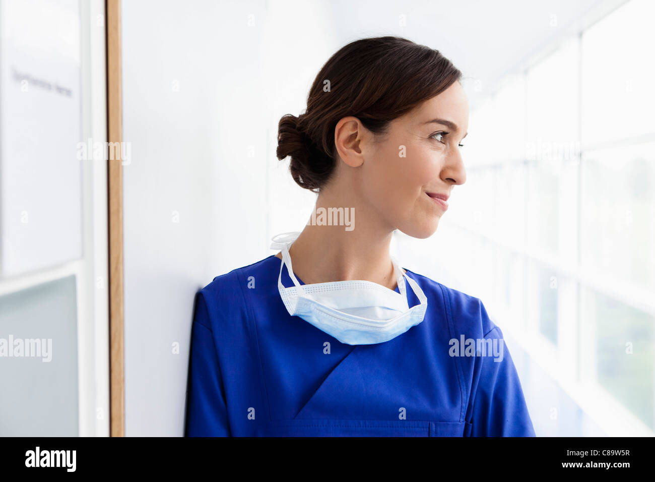 In Germania, in Baviera, Diessen am Ammersee, giovane medico in scrubs, sorridente Foto Stock