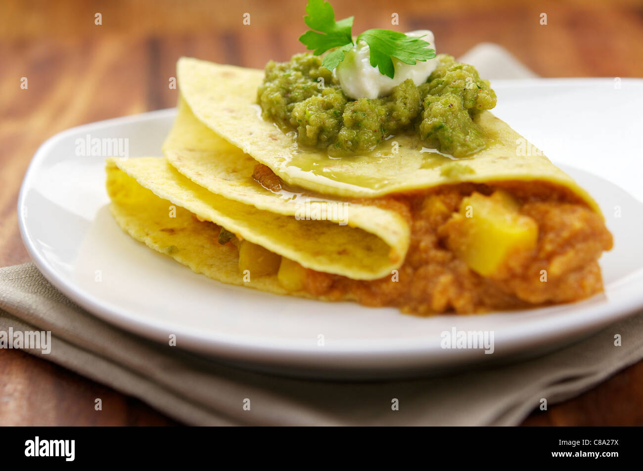 Un messicano vegane pranzo con campo da squash o la zucca in una tortilla di farina e Salsa Tomatilla (Salsa verde cruda) sulla parte superiore. Foto Stock