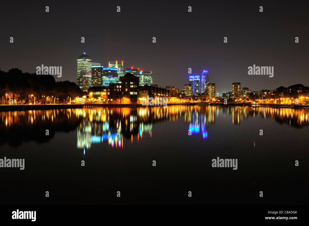 Canary Wharf skyline, accesa durante la notte, dal Surrey Quays nei Docklands di Londra, Regno Unito Foto Stock