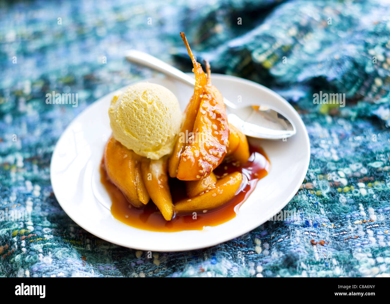 Pere caramellate con una pallina di gelato alla vaniglia Foto Stock