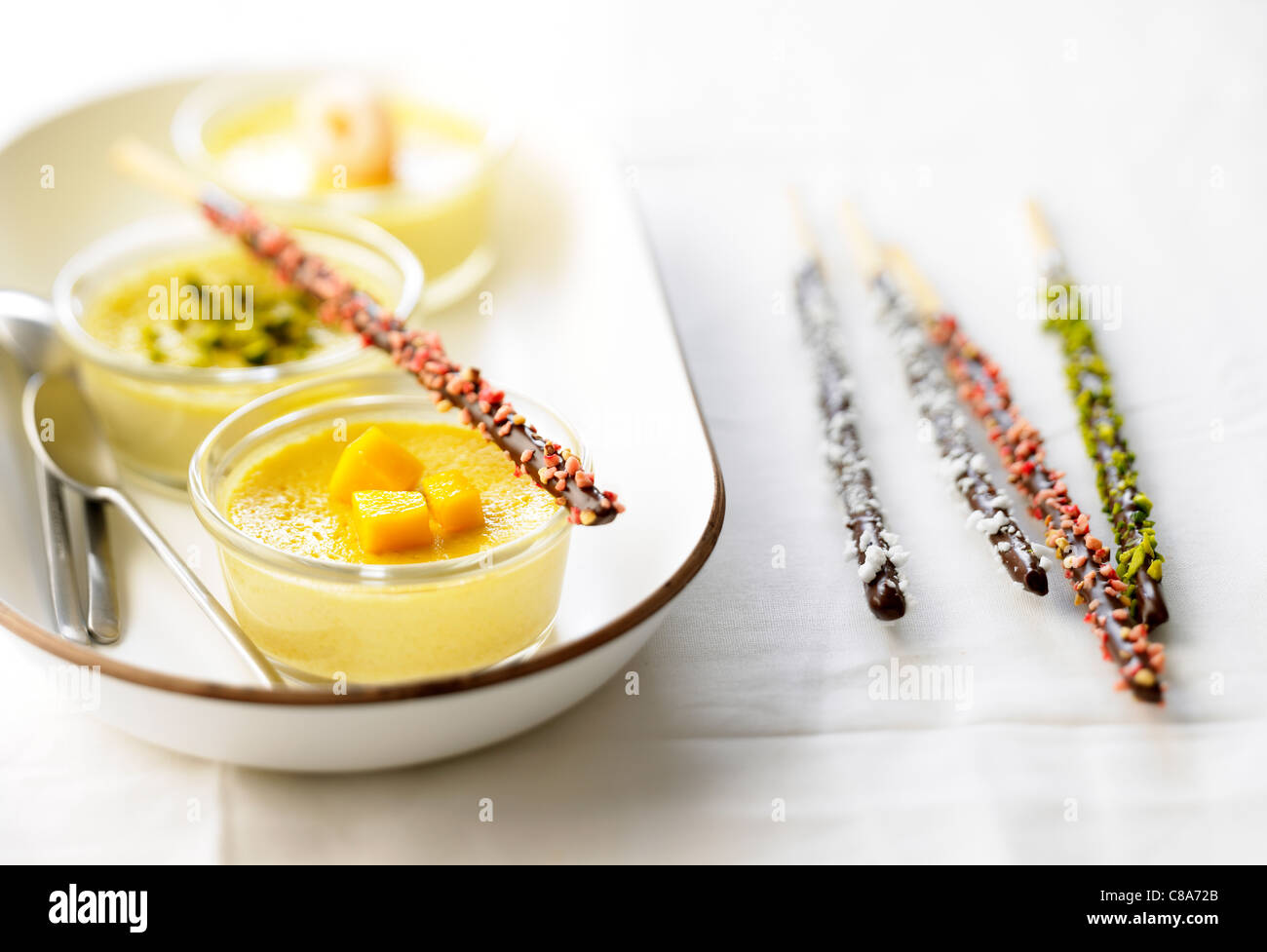 Tre differenti aromatizzati della crema dessert e Mikados Foto Stock