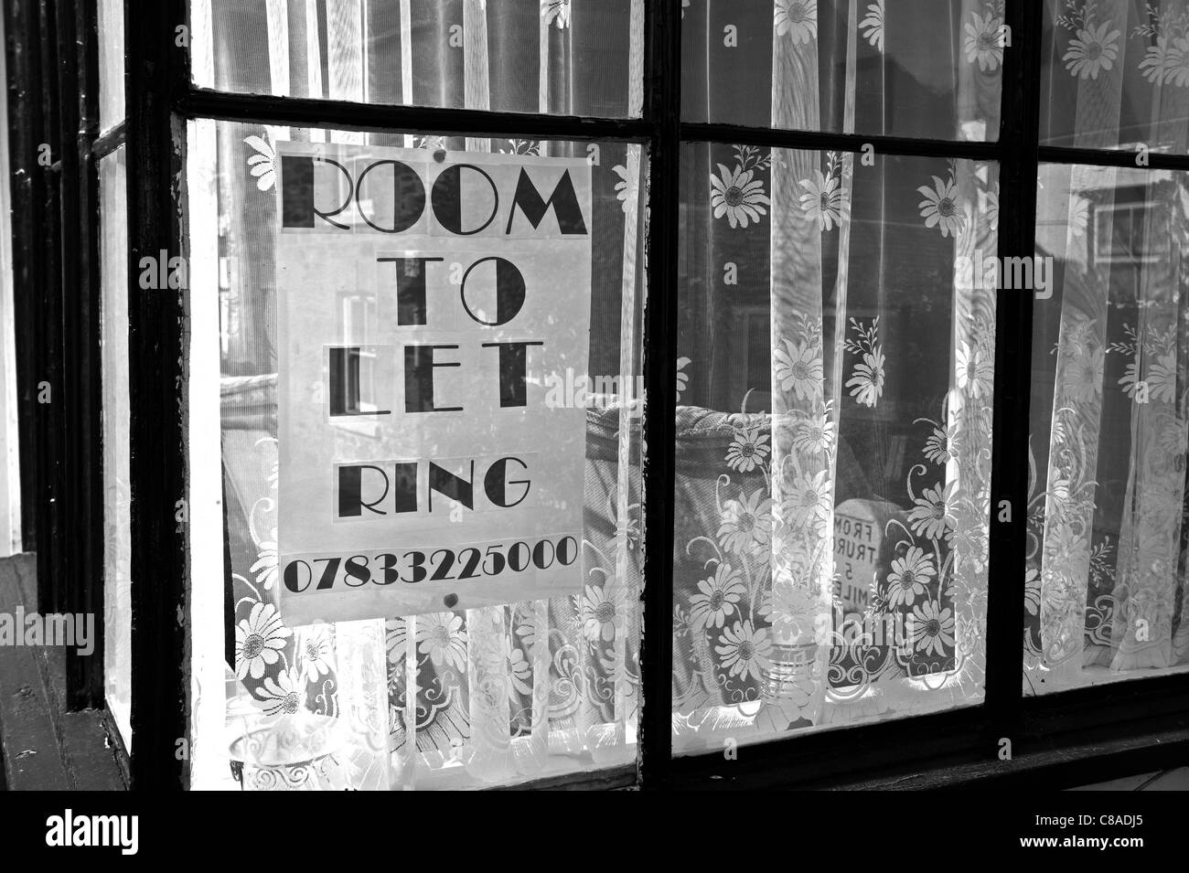 Un segno in una casa pubblicità la finestra di una camera in affitto Foto Stock