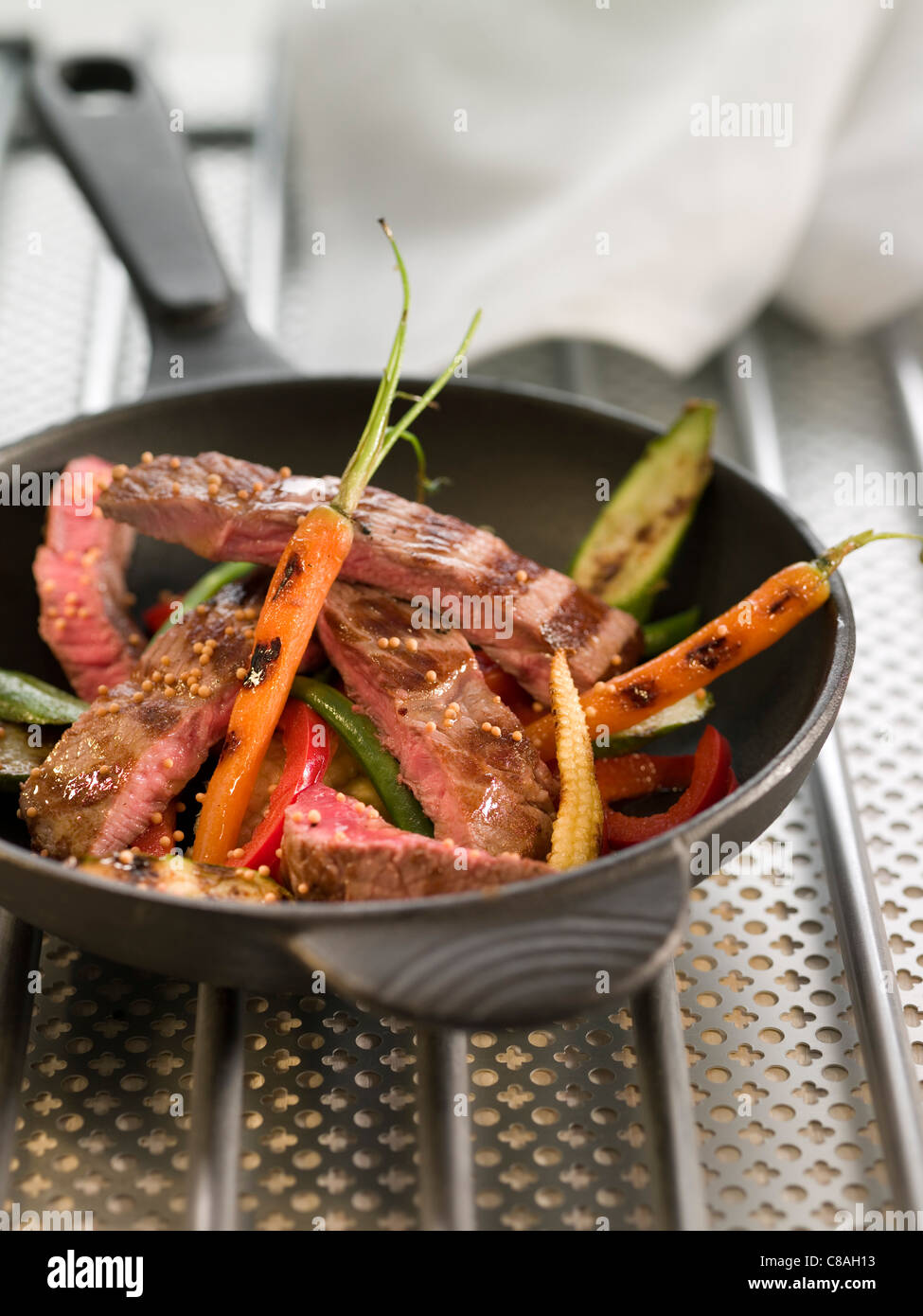 Affettato bistecca di vitello con giovani di verdure e di semi di senape Foto Stock