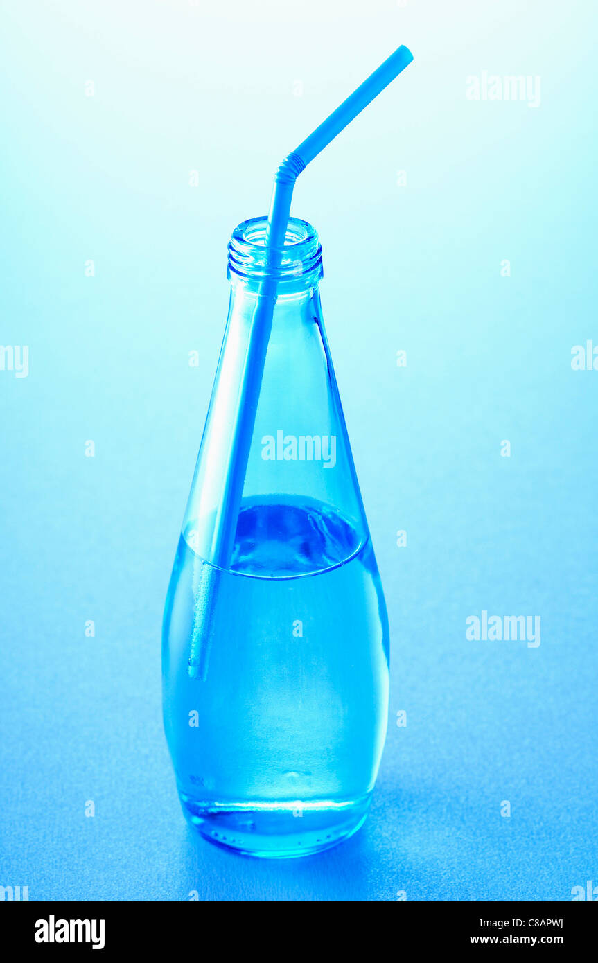Bottiglia di vetro di acqua con una cannuccia Foto Stock