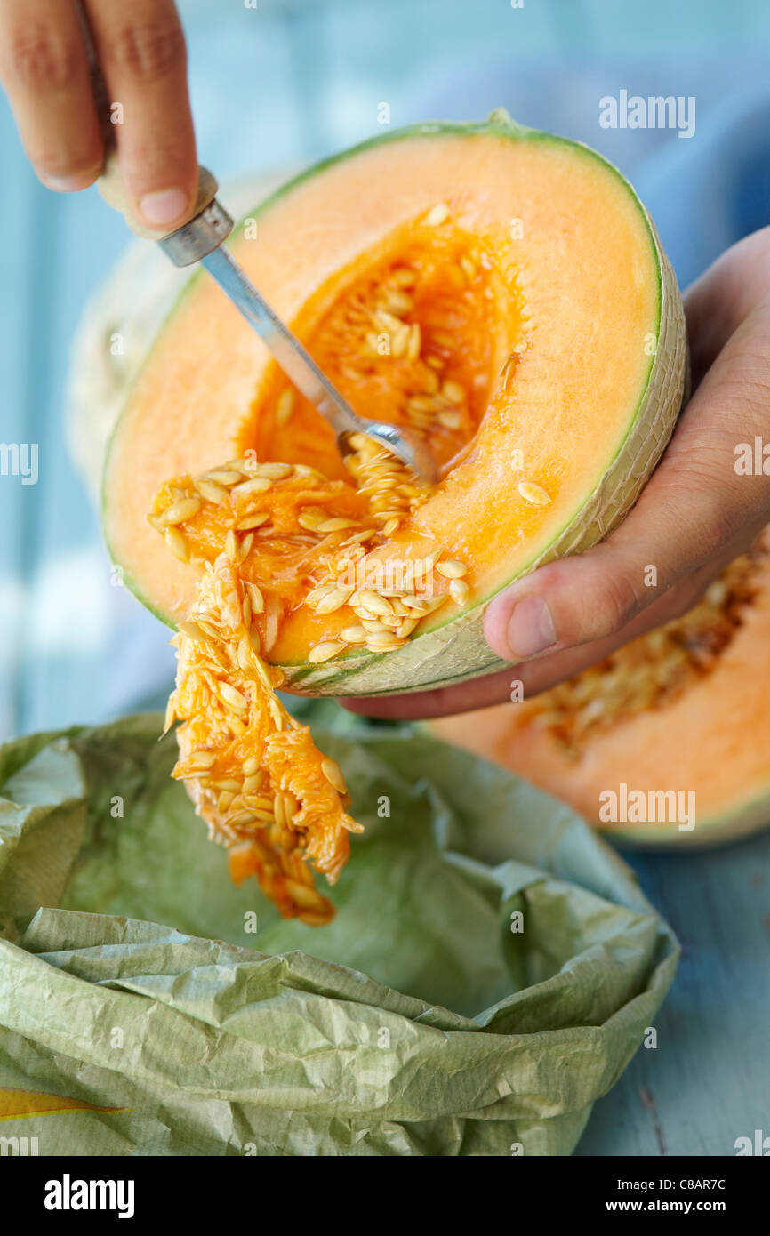Prendendo i semi al di fuori di un melone Foto Stock