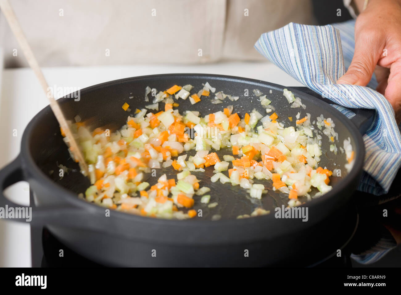 Agitazione i dadini di carote e sedano in una padella Foto Stock