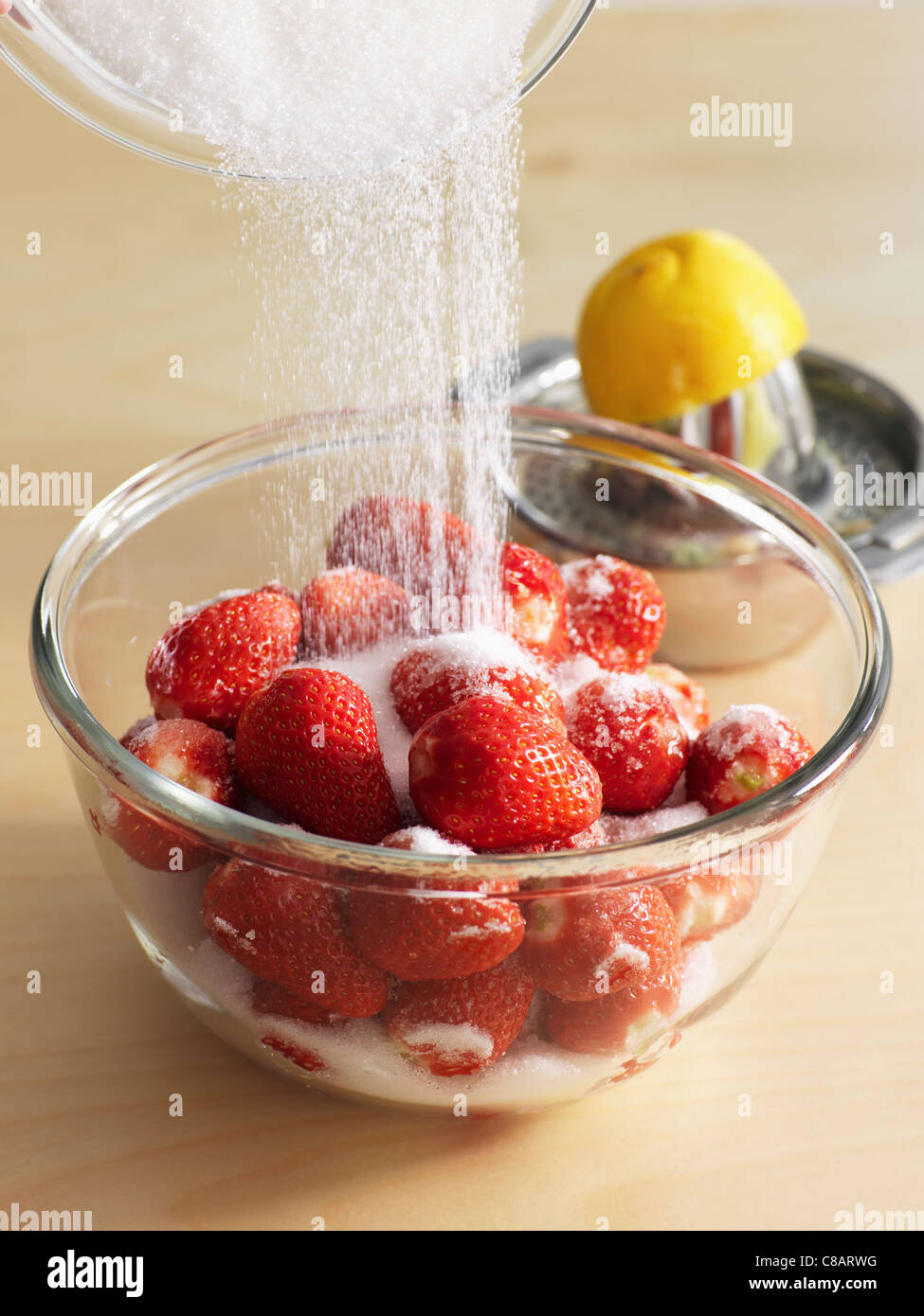 Versare lo zucchero oltre le fragole e lasciare macaerate con succo di limone Foto Stock