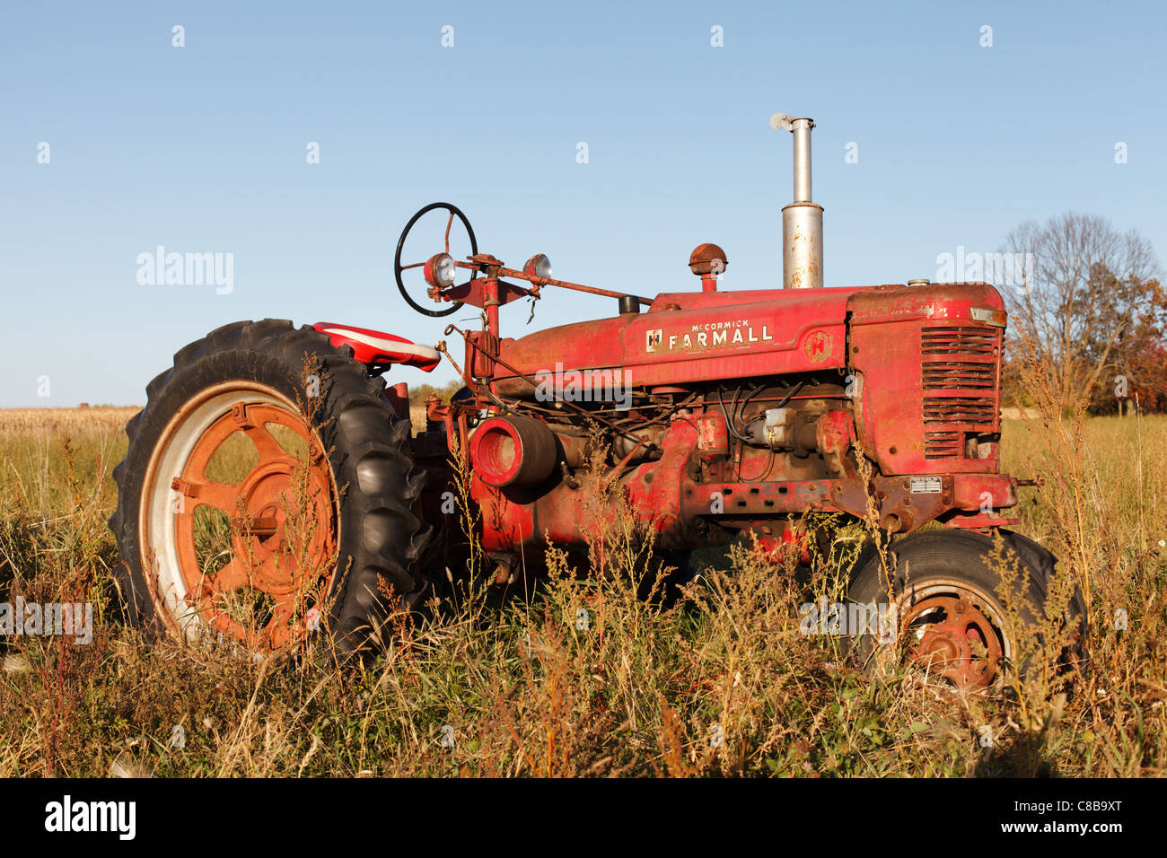 Un vecchio, rosso trattore Farmall seduto in un campo, northern Minnesota. Foto Stock