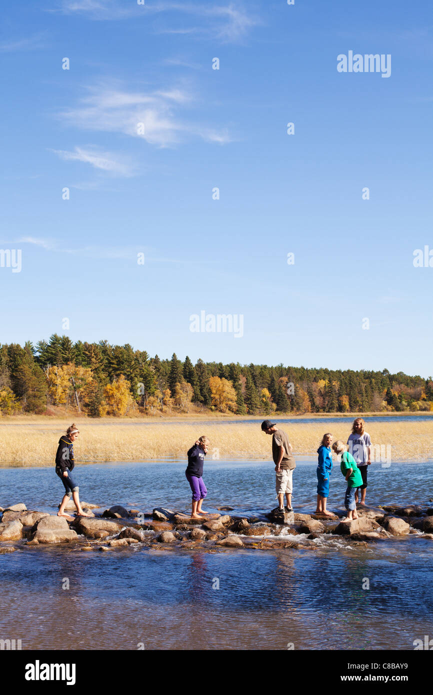 Giovani attraversare le sorgenti del fiume Mississippi sul lago Itasca nel nord del Minnesota. Foto Stock