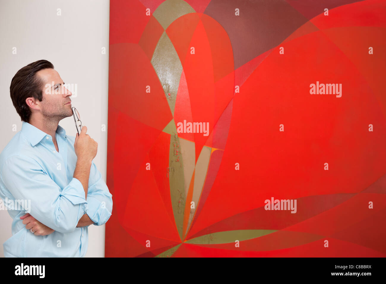 Considerato giovane uomo che guarda un dipinto nella galleria d'arte Foto Stock