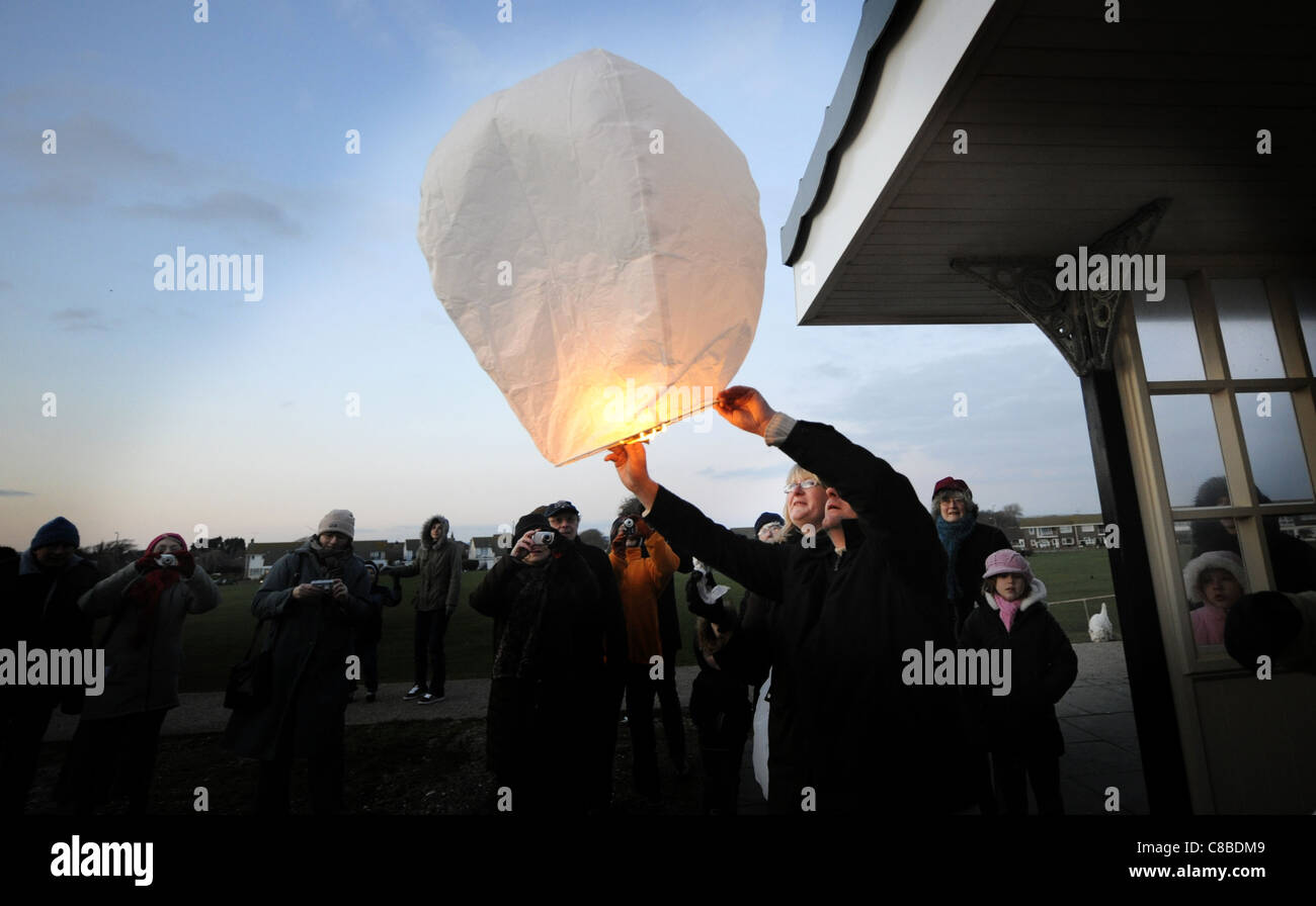 I membri di Worthing chiese progetti senzatetto battaglia con il vento che tentano di rilasciare le lanterne cinesi REGNO UNITO Foto Stock