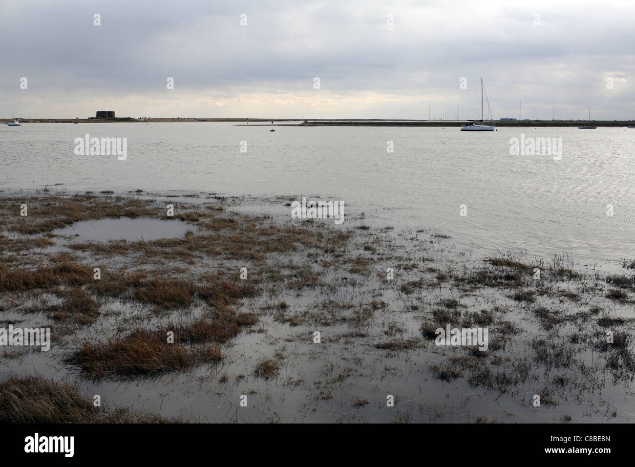 Alta Marea a Slaughden sul fiume Alde, Martello Tower sull orizzonte & Sky, Suffolk, Regno Unito Foto Stock