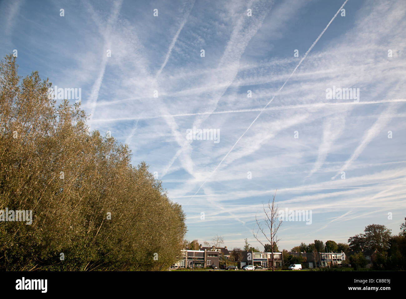Cielo blu pieno di sentieri a getto, Alblasserdam, Olanda Foto Stock
