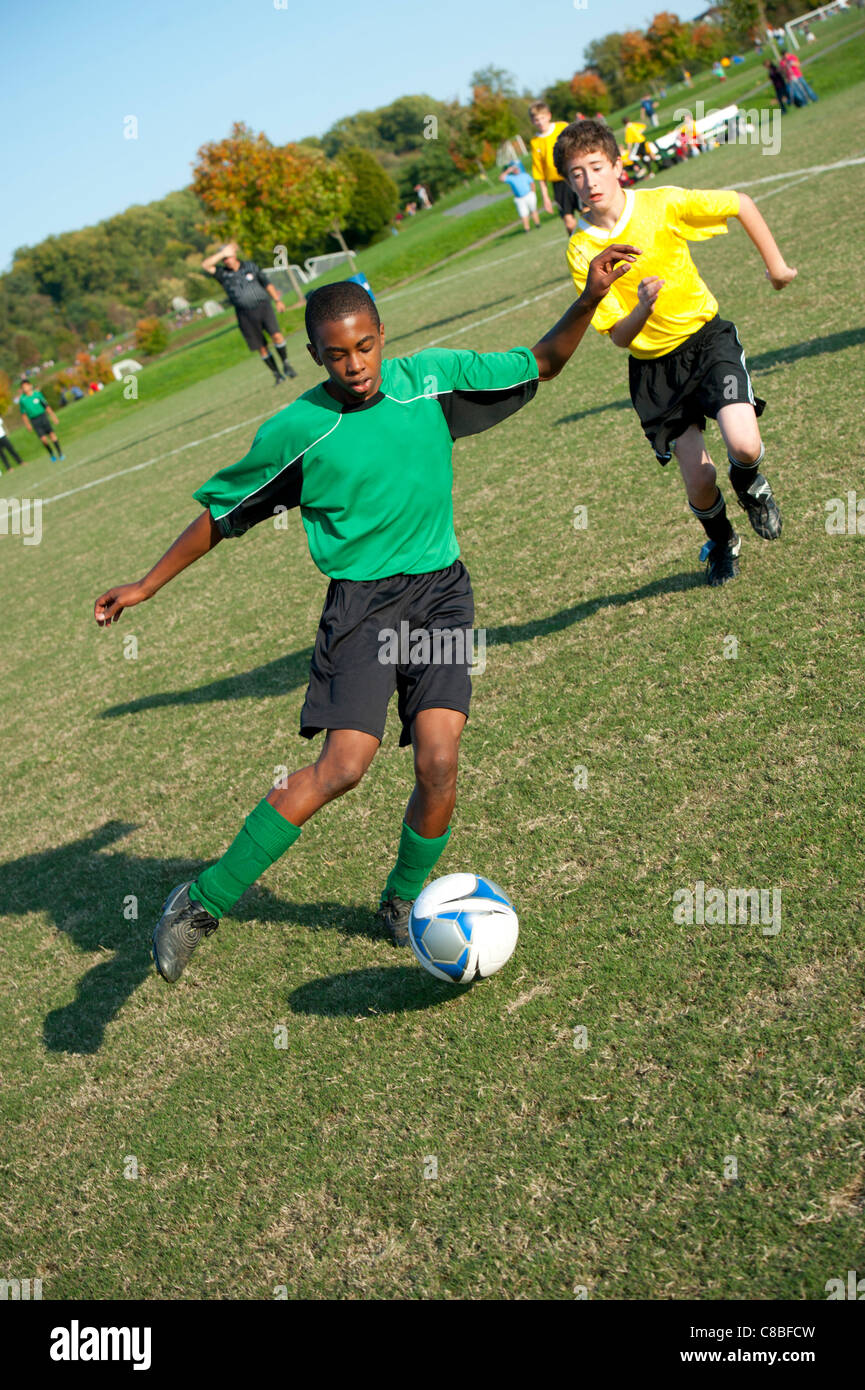 Ragazzi 11 12 13 giocando soccer football futball in una gioventù sports league Foto Stock