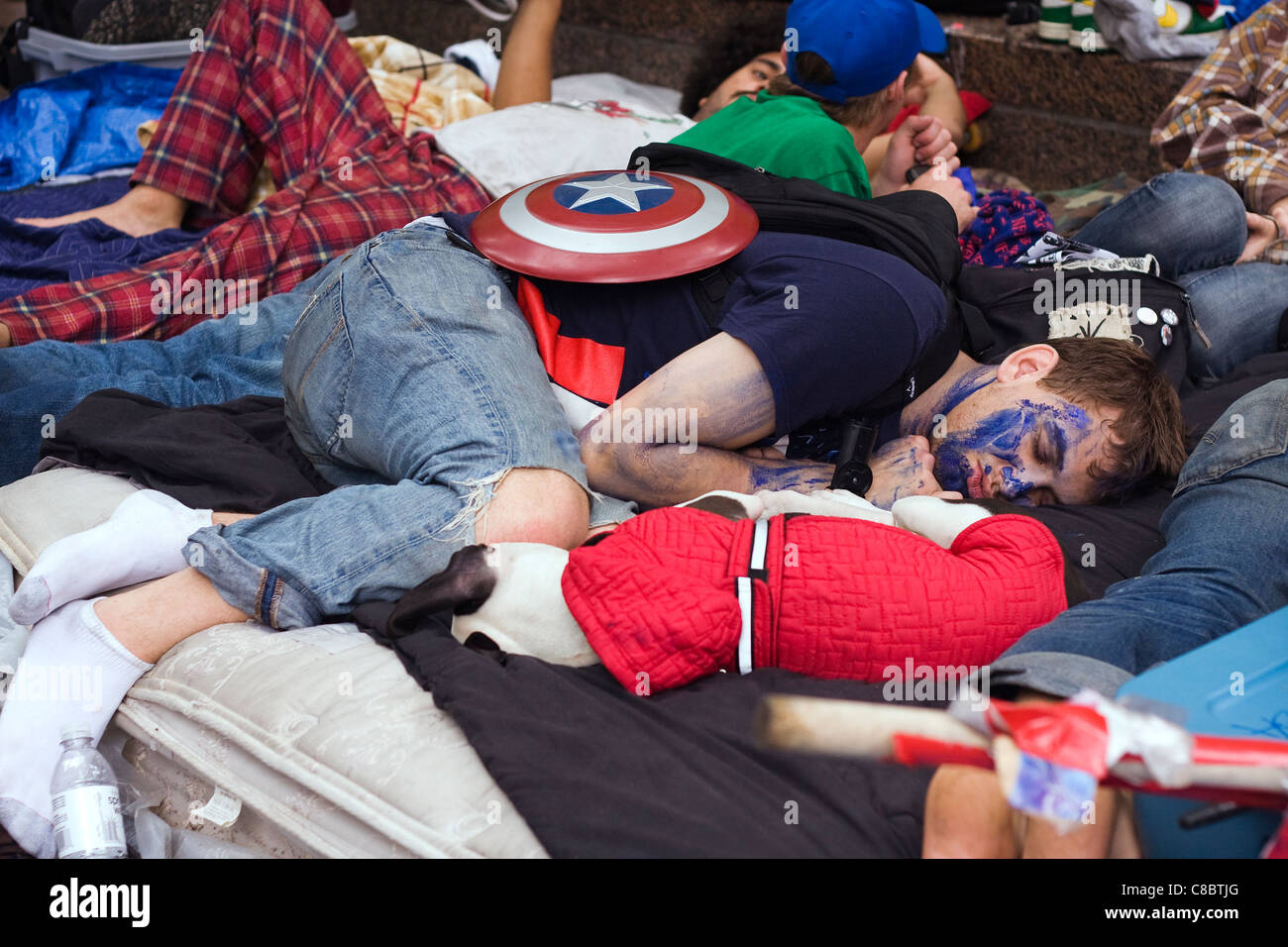 Occupare Wall Street Protester con il cap. America Shield dorme dopo un tempo trascorso la notte la pulizia Zuccotti Park dal 14 ottobre, 2011 Foto Stock