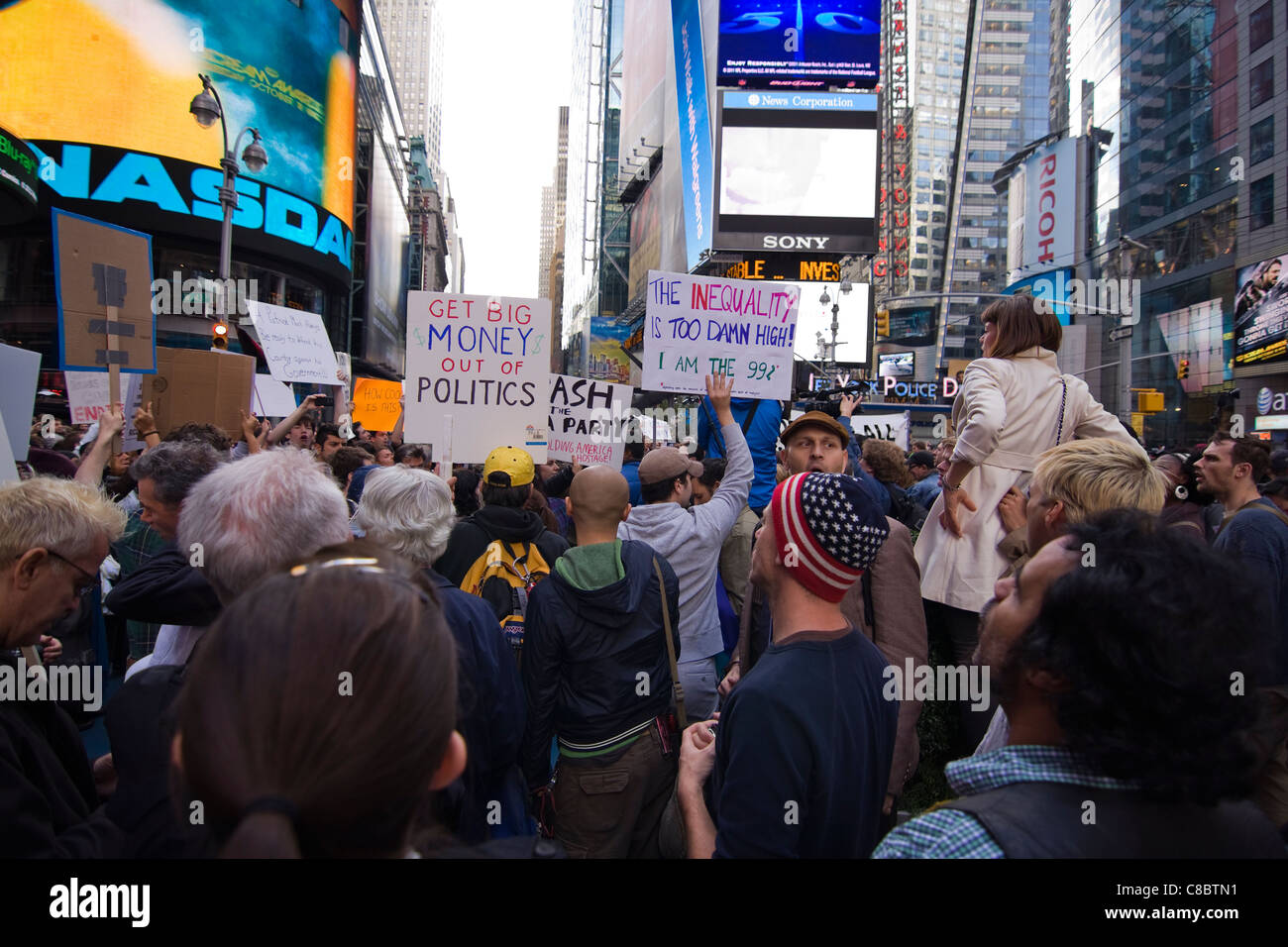 Migliaia di occupare Wall Street manifestanti holding segni in Times Square a New York City il 15 ottobre 2011 Foto Stock