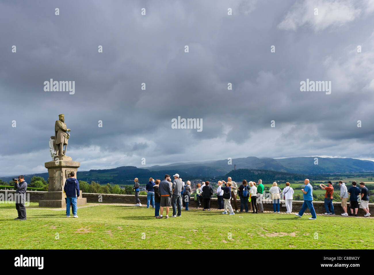 Turisti sotto la statua di Robert the Bruce al di fuori del Castello di Stirling, Stirling, Scozia, Regno Unito Foto Stock