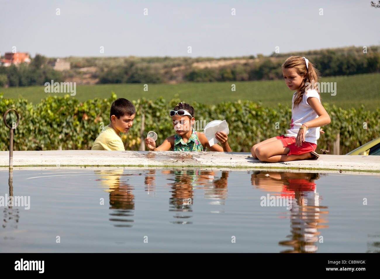 I bambini giocando da vigna serbatoio acqua serbatoio di irrigazione Foto Stock