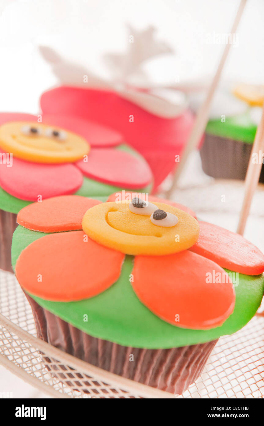 Rosso arancione e verde fiore smiley tortini di cioccolato su supporto Foto Stock