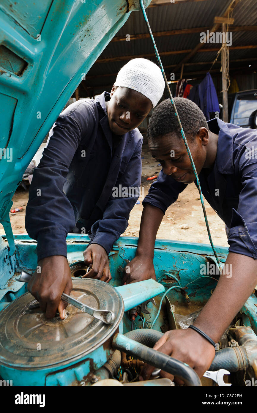 Partecipante meccanica lavorando su una vettura a motore, Thika, Kenya. Foto Stock